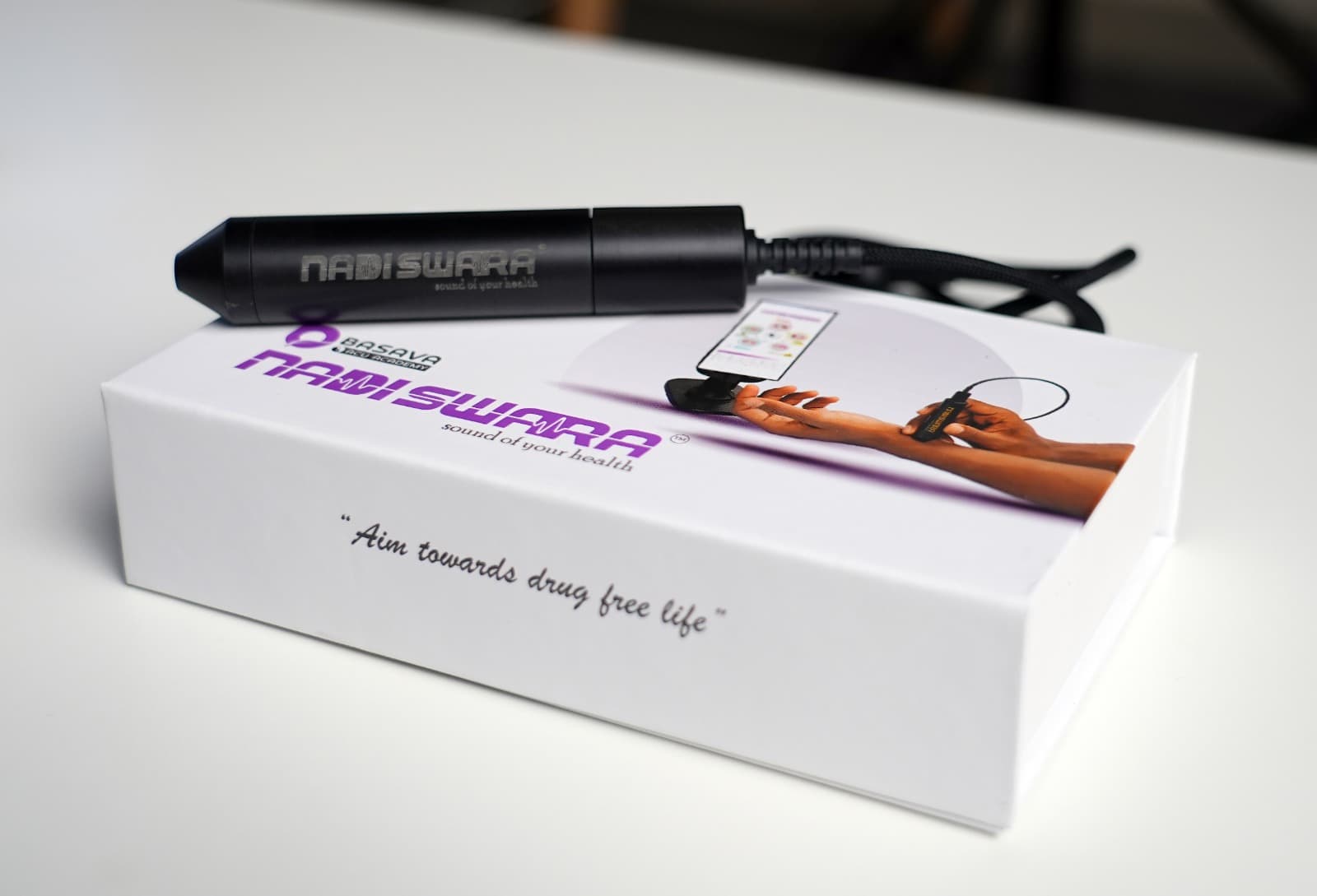 The black Nadiswara pulse sensor resting on its white box